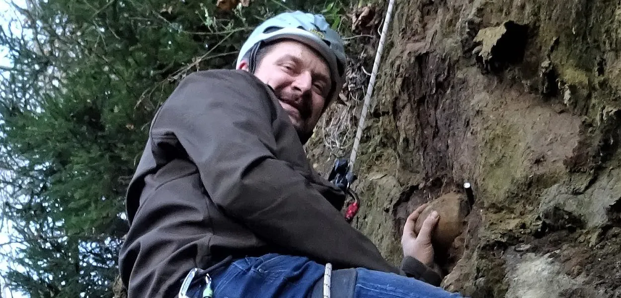 Michael Loidl seilt sich ab in eine Felswand um ein Fossil zu bergen.